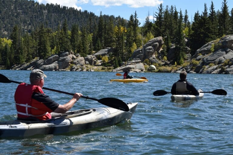 three people kayaking in a river